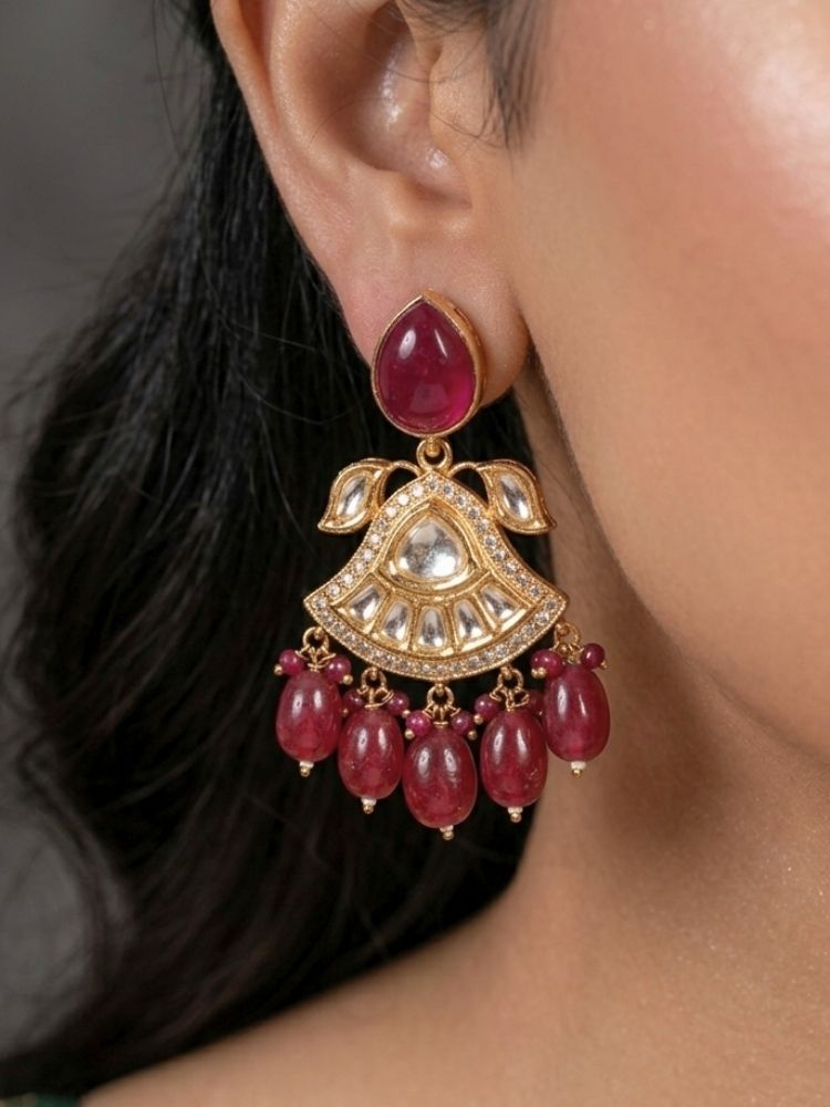 Close-up of a woman wearing an ornate traditional (Gold Polish) Ruby Red Choker jewellery set and earrings and maangtikka with Polki, Tumble Beads and Ruby Red Colored Stones. Woman wearing trending Polki artificial jewelry for the wedding season in India. Festive celebration look completed with premium imitation Polki jewelry.