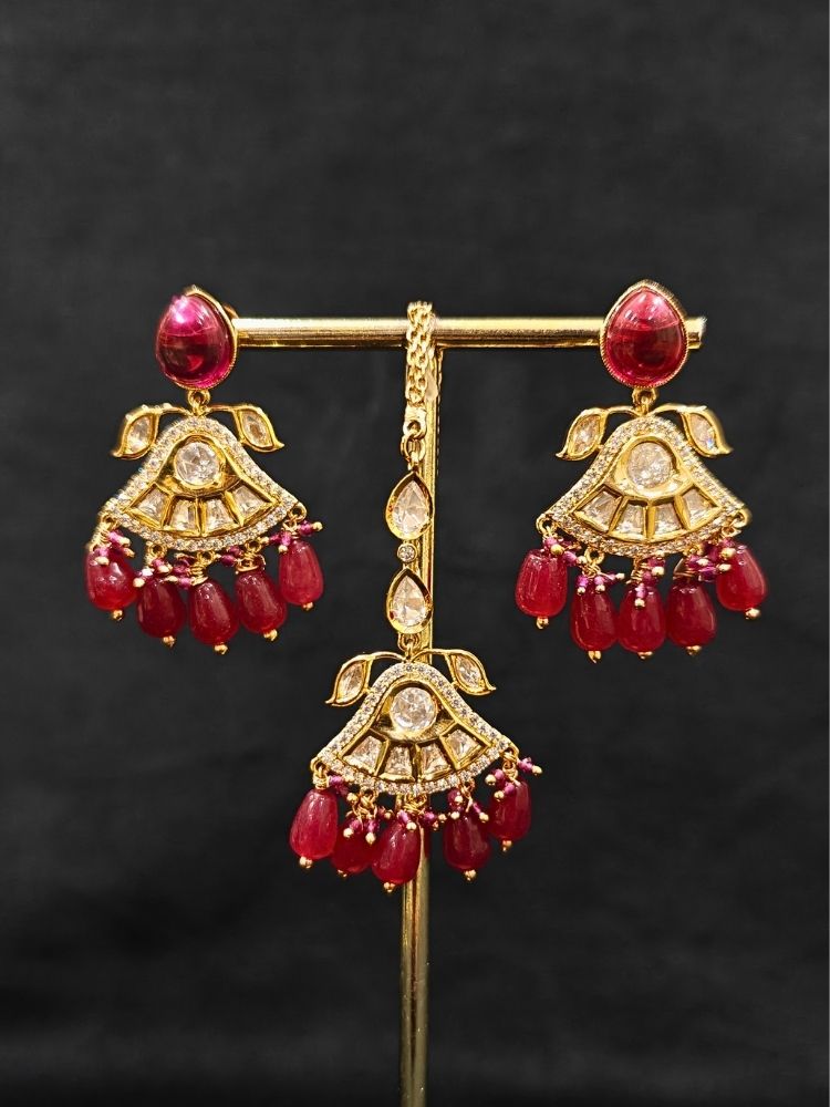 Close-up of an ornate traditional (Gold Polish) Ruby Red Choker jewellery set and earrings and maangtikka with Polki, Tumble Beads and Ruby Red Colored Stones. Woman wearing trending Polki artificial jewelry for the wedding season in India. Festive celebration look completed with premium imitation Polki jewelry.