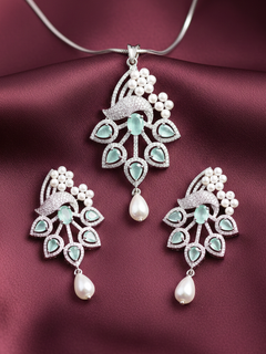 Close-up of an ornate Indo-western Mint Green (Silver Polish)  Pendant set and earrings with American Diamonds, Colored Stones and Pearls. A statement American diamond Pendant with an off-shoulder gown for a reception. Indo-western outfit styled with a statement American diamond Pendant set.