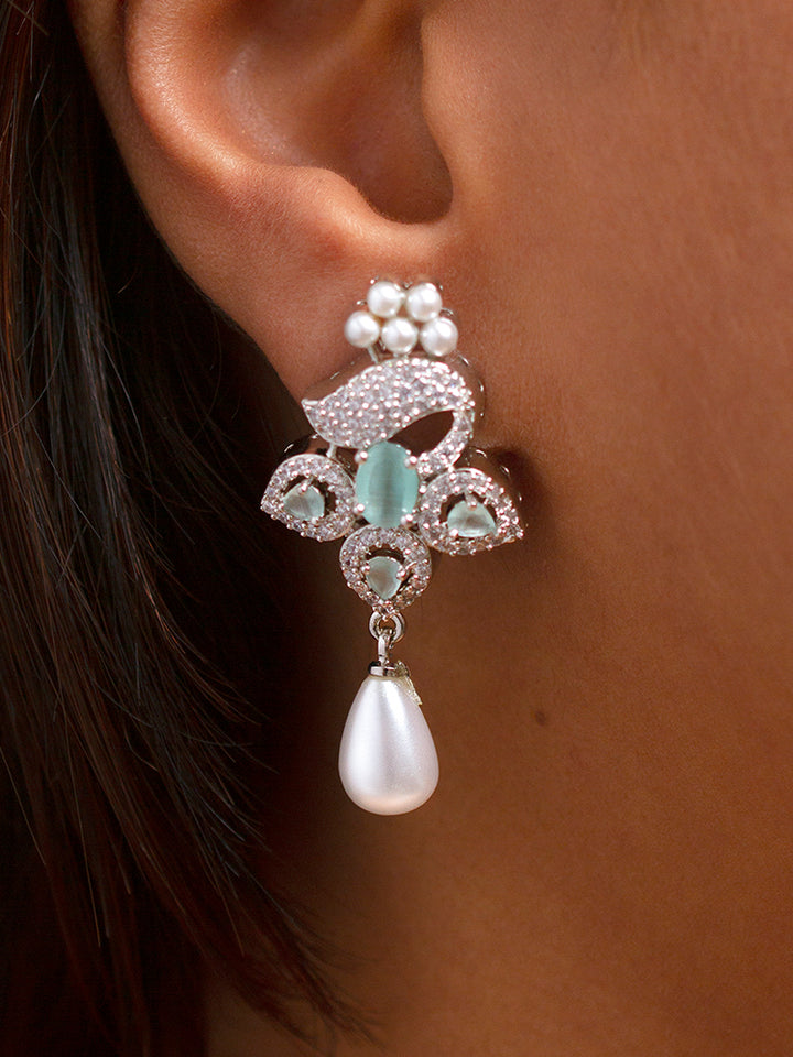 Close-up of a woman wearing an ornate Indo-western Mint Green (Silver Polish)  Pendant set and earrings with American Diamonds, Colored Stones and Pearls. Woman styling a statement American diamond Pendant with an off-shoulder gown for a reception. Indo-western outfit styled with a statement American diamond Pendant set.