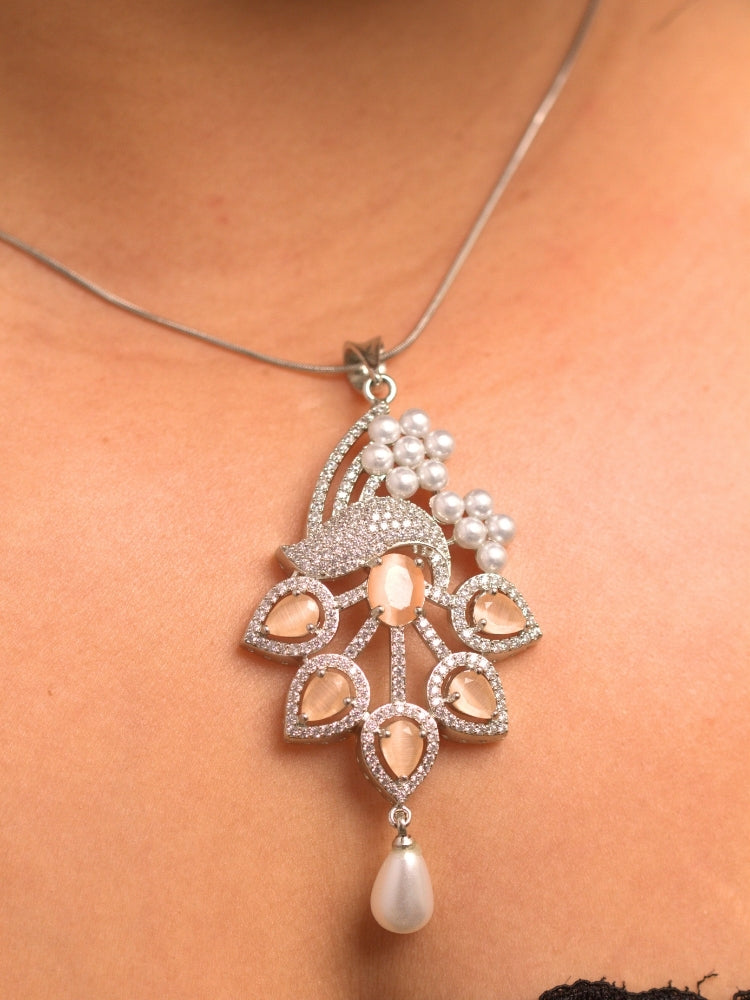 Close-up of a woman wearing an ornate Indo-western Peach (Silver Polish)  Pendant set and earrings with American Diamonds, Colored Stones and Pearls. Woman styling a statement American diamond Pendant with an off-shoulder gown for a reception. Indo-western outfit styled with a statement American diamond Pendant set.