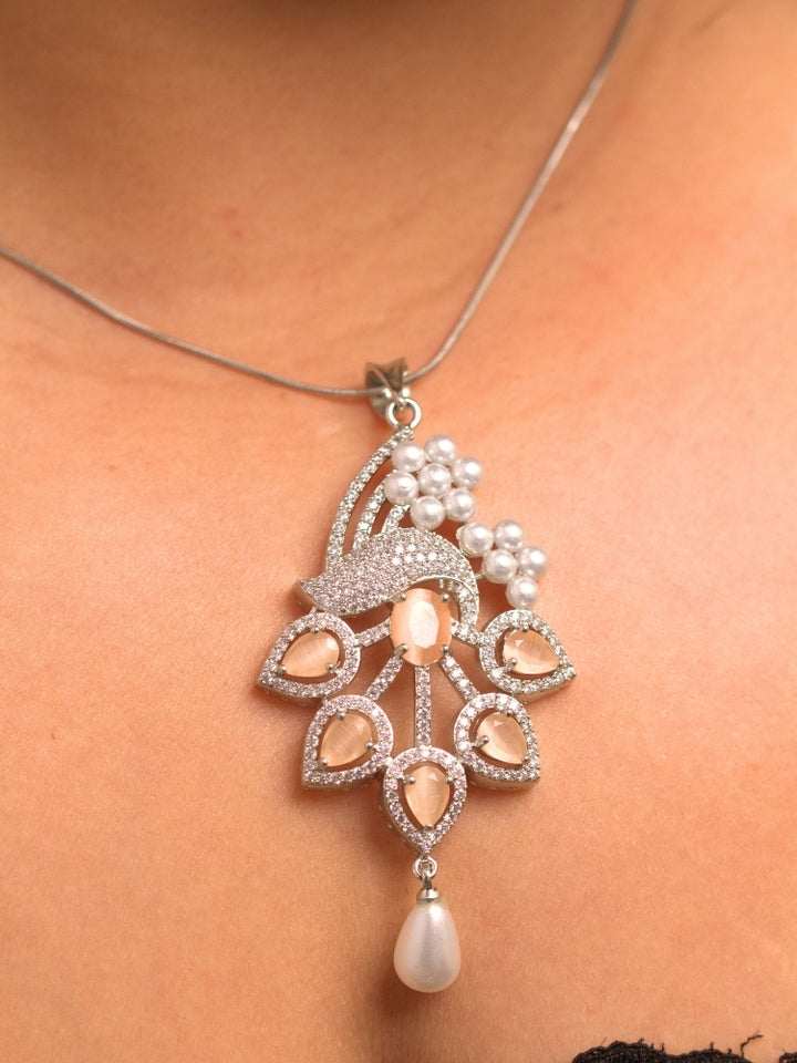 Close-up of a woman wearing an ornate Indo-western Peach (Silver Polish)  Pendant set and earrings with American Diamonds, Colored Stones and Pearls. Woman styling a statement American diamond Pendant with an off-shoulder gown for a reception. Indo-western outfit styled with a statement American diamond Pendant set.