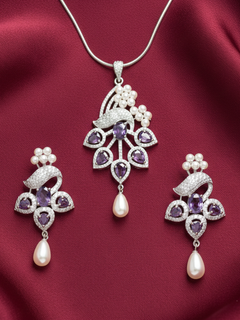 Close-up of an ornate Indo-western Purple (Silver Polish)  Pendant set and earrings with American Diamonds, Colored Stones and Pearls. A statement American diamond Pendant with an off-shoulder gown for a reception. Indo-western outfit styled with a statement American diamond Pendant set.