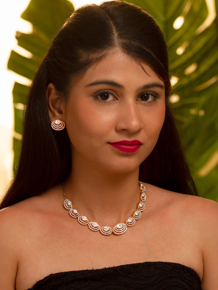 The Alice Necklace Set features a gold moissanite necklace with matching earrings, showcasing oval stones in circular designs made with moissanite, put on a teal velvet bust—perfect for elevating your cocktail jewelry style.
