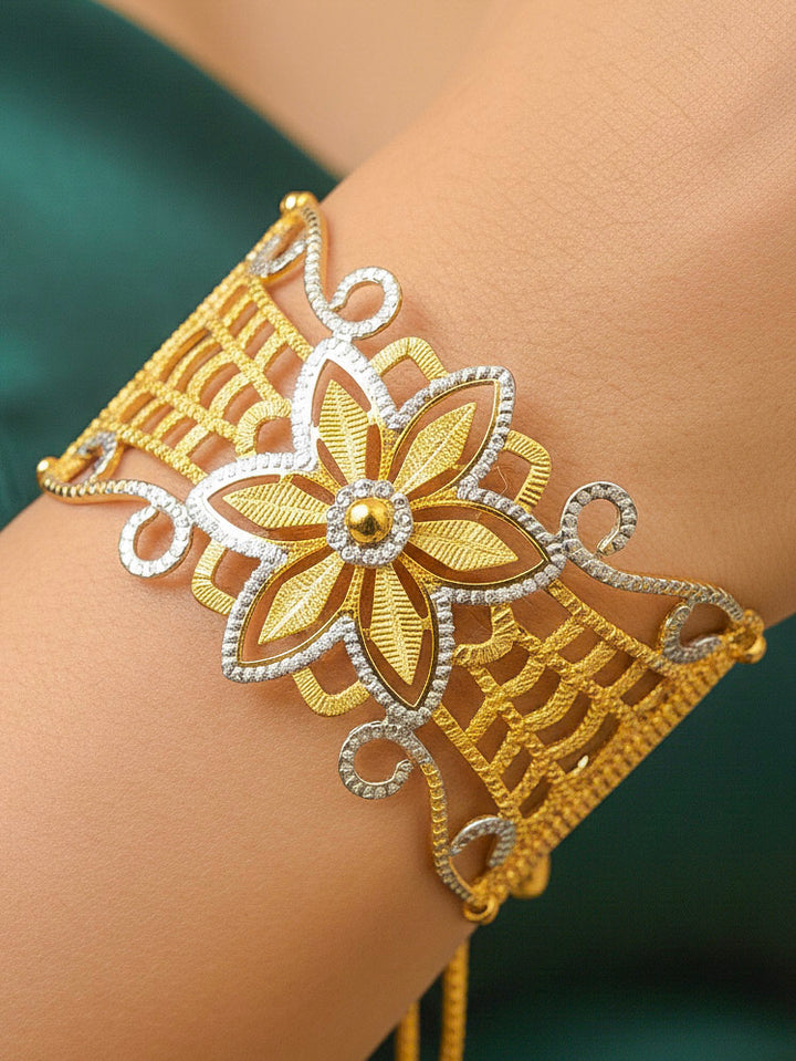 Close-up of a woman wearing an ornate traditional (Gold & Silver Polish) Bracelet. Close-up of an anti-tarnish artificial bracelet styled for wedding guests. Festive outfit paired with a premium imitation bracelet in India. 