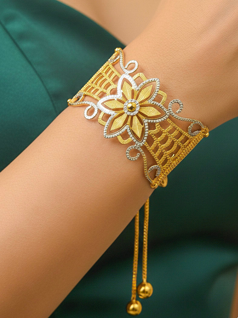 Close-up of a woman wearing an ornate traditional (Gold & Silver Polish) Bracelet. Close-up of an anti-tarnish artificial bracelet styled for wedding guests. Festive outfit paired with a premium imitation bracelet in India. 