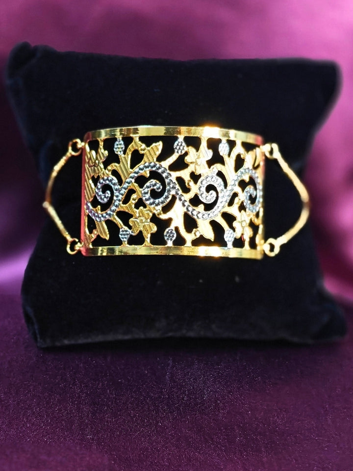 Close-up of an ornate traditional (Gold & Silver Polish) Bracelet. Close-up of an anti-tarnish artificial bracelet styled for wedding guests. Festive outfit paired with a premium imitation bracelet in India. 