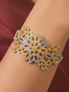 Close-up of a woman wearing an ornate traditional (Gold & Silver Polish) Bracelet. Close-up of an anti-tarnish artificial bracelet styled for wedding guests. Festive outfit paired with a premium imitation bracelet in India. 