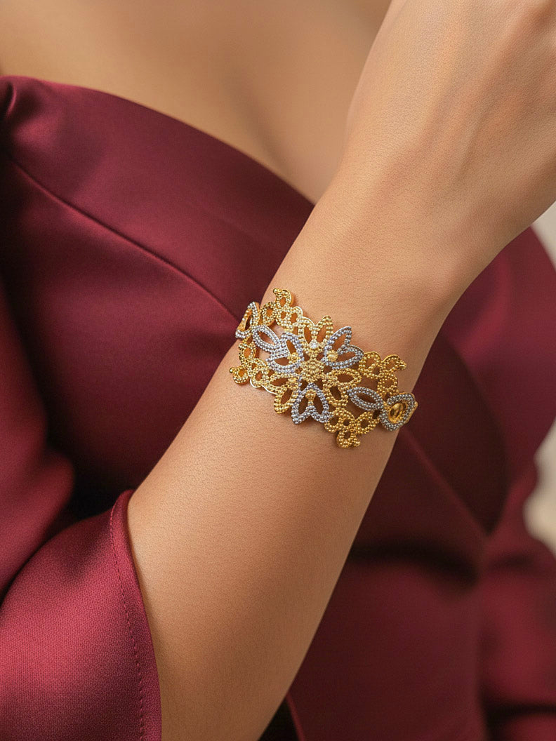 Close-up of a woman wearing an ornate traditional (Gold & Silver Polish) Bracelet. Close-up of an anti-tarnish artificial bracelet styled for wedding guests. Festive outfit paired with a premium imitation bracelet in India. 
