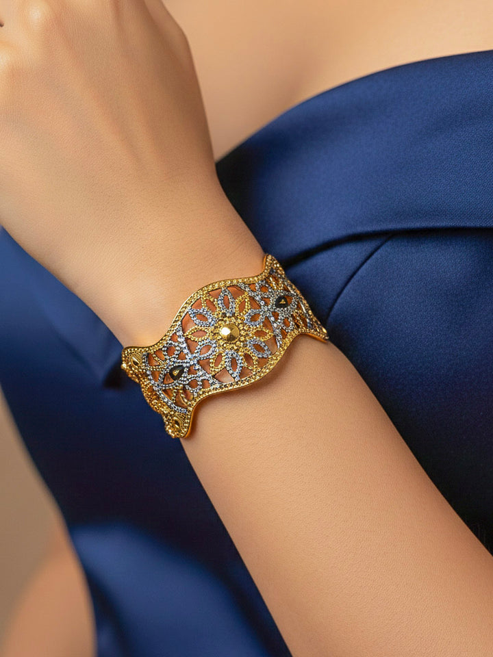Close-up of a woman wearing an ornate traditional (Gold & Silver Polish) Bracelet. Close-up of an anti-tarnish artificial bracelet styled for wedding guests. Festive outfit paired with a premium imitation bracelet in India. 