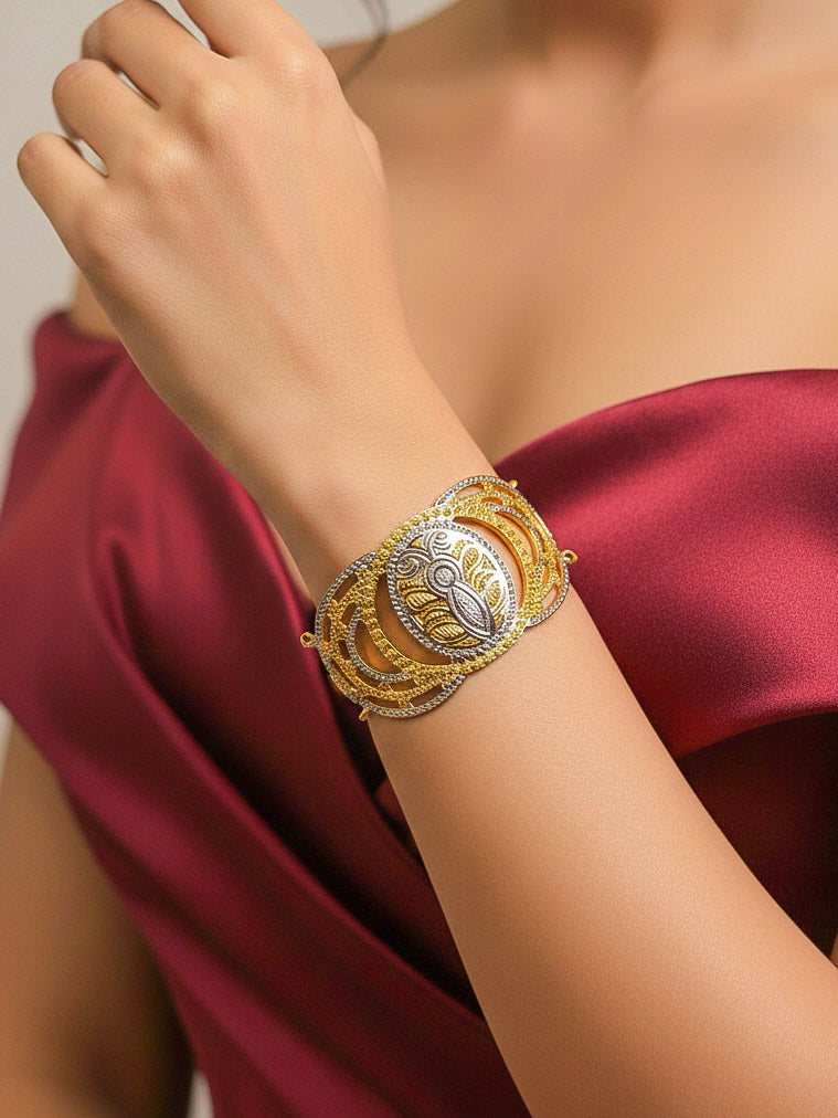 Close-up of a woman wearing an ornate traditional (Gold & Silver Polish) Bracelet. Close-up of an anti-tarnish artificial bracelet styled for wedding guests. Festive outfit paired with a premium imitation bracelet in India. 