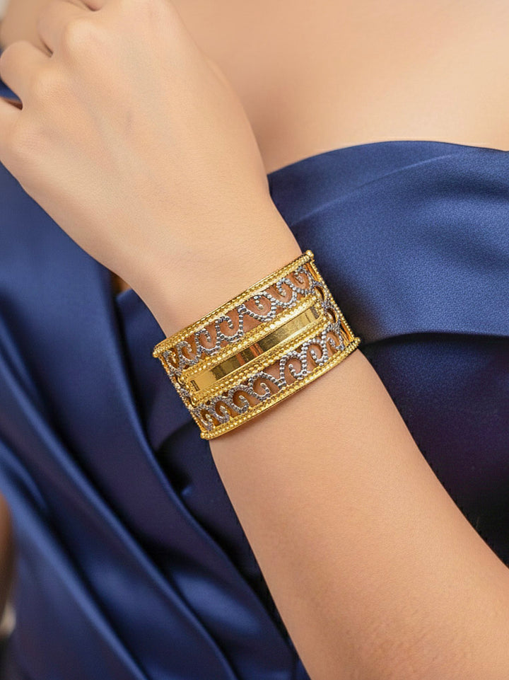 Close-up of a woman wearing an ornate traditional (Gold & Silver Polish) Bracelet. Close-up of an anti-tarnish artificial bracelet styled for wedding guests. Festive outfit paired with a premium imitation bracelet in India. 