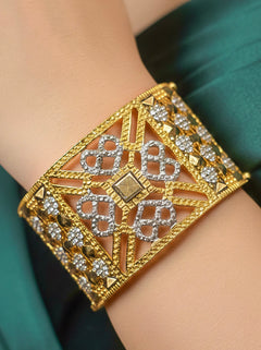 Close-up of a woman wearing an ornate traditional (Gold & Silver Polish) Bracelet. Close-up of an anti-tarnish artificial bracelet styled for wedding guests. Festive outfit paired with a premium imitation bracelet in India. 
