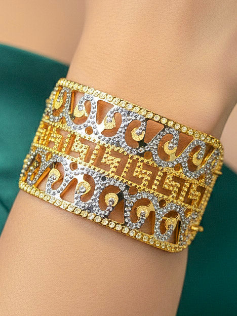 Close-up of a woman wearing an ornate traditional (Gold & Silver Polish) Bracelet. Close-up of an anti-tarnish artificial bracelet styled for wedding guests. Festive outfit paired with a premium imitation bracelet in India. 