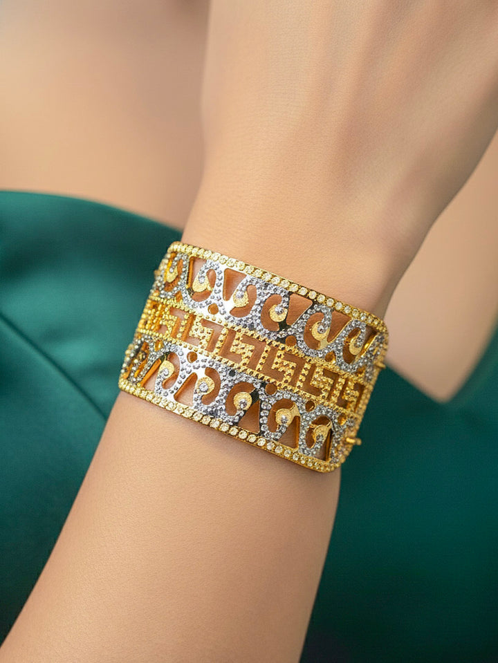 Close-up of a woman wearing an ornate traditional (Gold & Silver Polish) Bracelet. Close-up of an anti-tarnish artificial bracelet styled for wedding guests. Festive outfit paired with a premium imitation bracelet in India. 