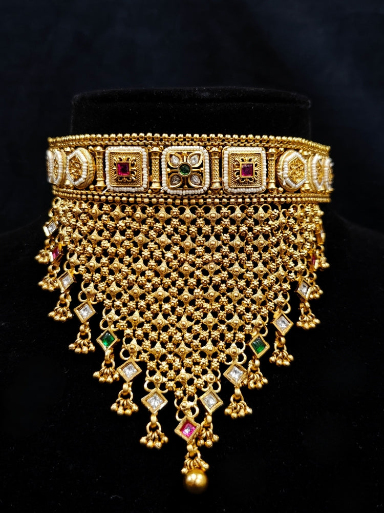 Close-up of an ornate traditional Rajwadi gold Choker jewellery set and earrings with Brass, Stones, Pearls and Bandhai Work. Festive look completed with a luxury Rajwadi imitation necklace. Close-up of a premium Rajwadi artificial necklace under 10000. Perfect Rajwadi necklace set for weddings and festivals.