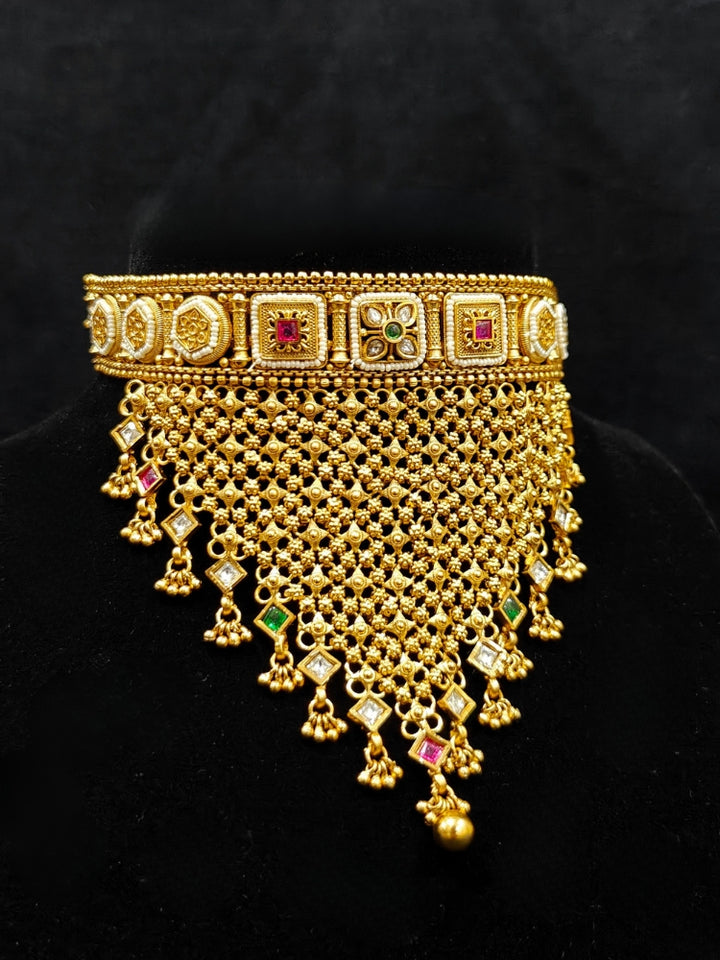 Close-up of an ornate traditional Rajwadi gold Choker jewellery set and earrings with Brass, Stones, Pearls and Bandhai Work. Festive look completed with a luxury Rajwadi imitation necklace. Close-up of a premium Rajwadi artificial necklace under 10000. Perfect Rajwadi necklace set for weddings and festivals.