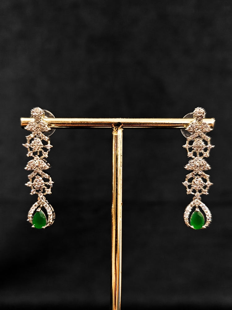 A gorgeous artificial diamond and green colored stone necklace paired with diamond earrings. This artificial diamond jewelry set offers a traditional yet modern touch for Indian brides, designed to add elegance and sophistication to any occasion.