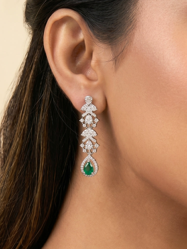 "A woman in a traditional saree, wearing a gorgeous artificial diamond and green colored stone necklace paired with diamond earrings. This artificial diamond jewelry set offers a traditional yet modern touch for Indian brides, designed to add elegance and sophistication to any occasion."

