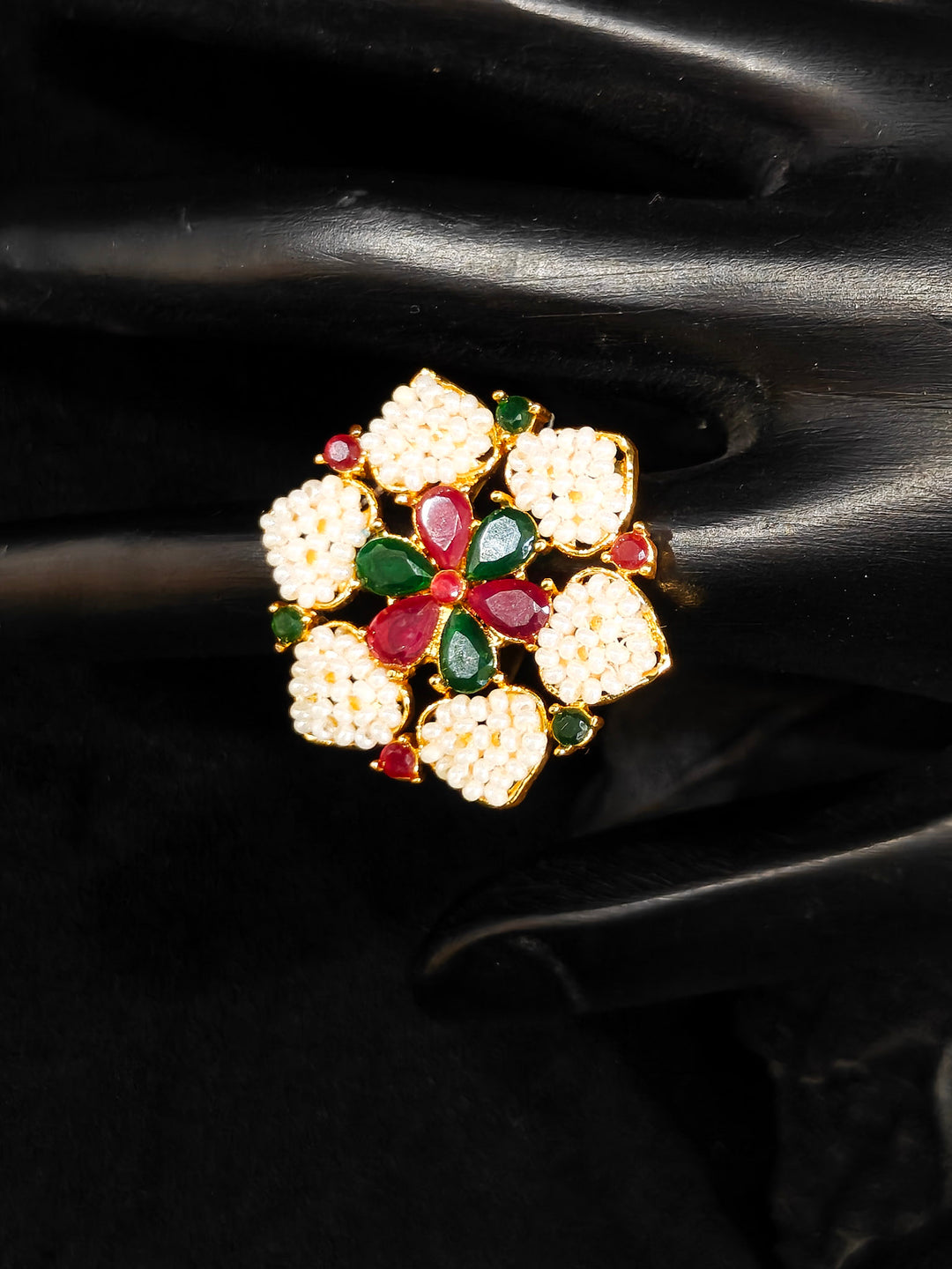 Close-up of an ornate traditional (Bright Gold Polish) Red,Green and White Collar jewellery set and earrings and Ring with Pearls and Red & Green Colored Stones. Mehendi ceremony look completed with a handcrafted Pearl jewelry set. Woman wearing a vibrant Pearl artificial jewelry set for celebrations.