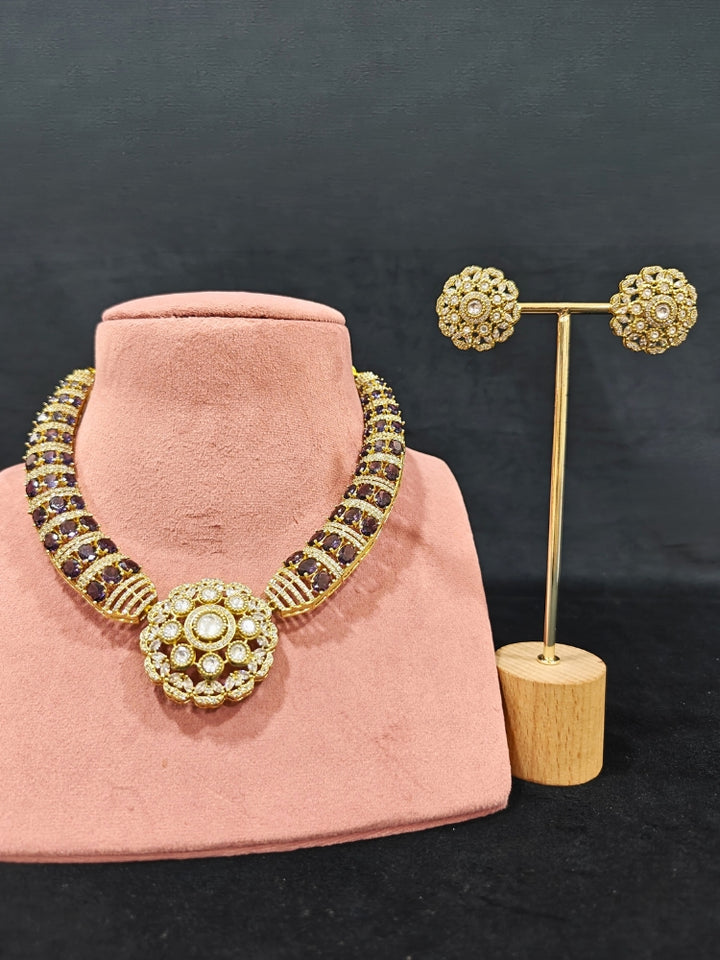 Close-up of an ornate traditional Purple Collar Gold jewellery set and earrings with American Diamond and Colored Stones. Mehendi function outfit styled with a lightweight American Diamond necklace. Festive celebration look featuring a American Diamond artificial necklace.