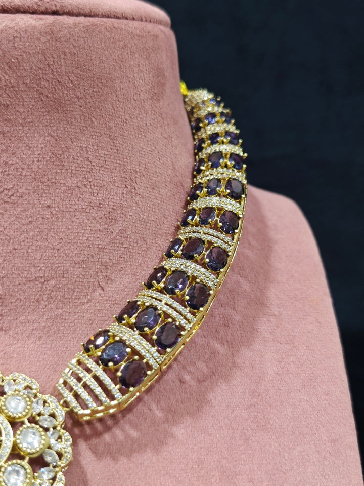 Close-up of an ornate traditional Purple Collar Gold jewellery set and earrings with American Diamond and Colored Stones. Mehendi function outfit styled with a lightweight American Diamond necklace. Festive celebration look featuring a American Diamond artificial necklace.
