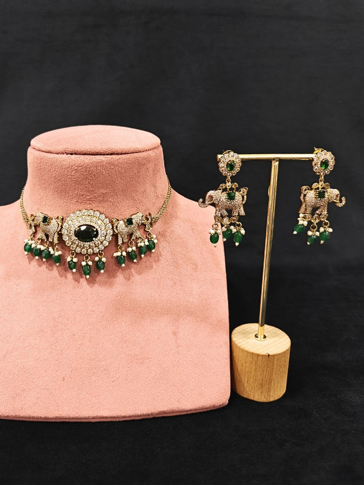 Close-up of an ornate traditional Dark Green (Mehendi gold Polish) Choker Diamond jewellery set and earrings with American Diamond, Colored Stone and Pearls. Elegant festive look with a high-quality imitation American diamond necklace set. A luxury American diamond necklace set styled beautifully for a wedding guest look in India.