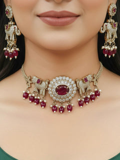 Close-up of a woman wearing an ornate traditional Maroon (Mehendi gold Polish) Choker Diamond jewellery set and earrings with American Diamond, Pearls and Colored Stone. Elegant festive look with a high-quality imitation American diamond necklace set. A woman wearing a luxury American diamond necklace set styled beautifully for a wedding guest look in India.