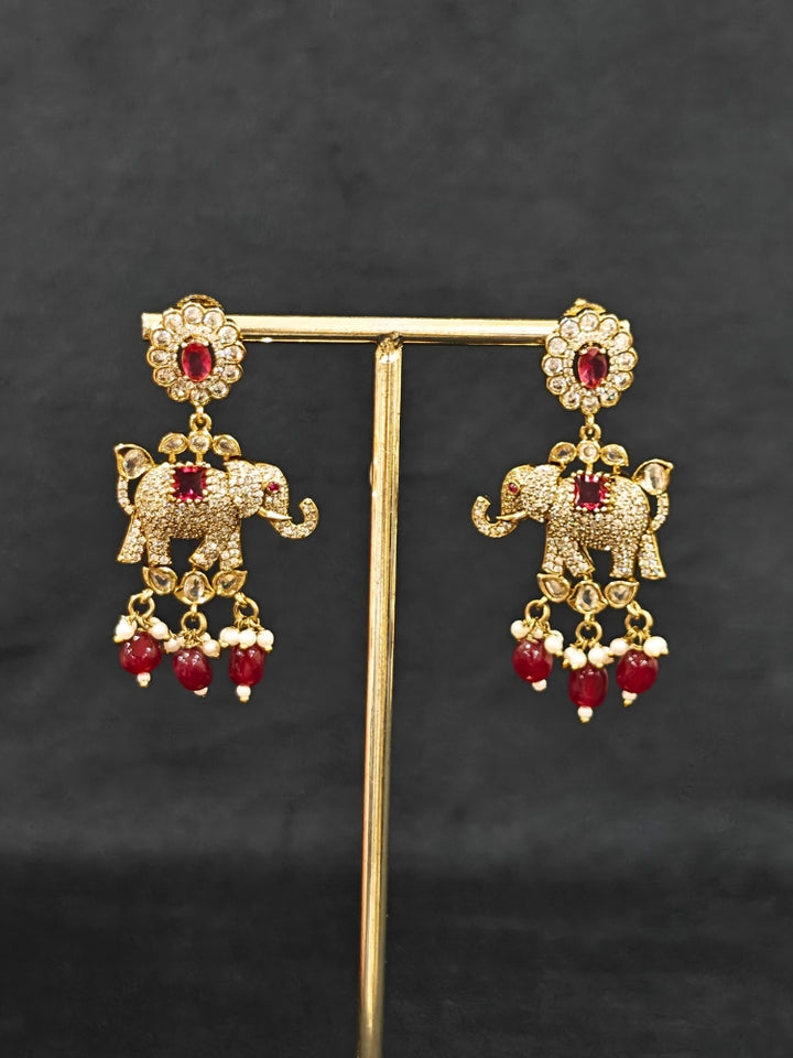Close-up of an ornate traditional Maroon (Mehendi gold Polish) Choker Diamond jewellery set and earrings with American Diamond, Pearls and Colored Stone. Elegant festive look with a high-quality imitation American diamond necklace set. A luxury American diamond necklace set styled beautifully for a wedding guest look in India.