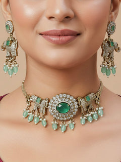 Close-up of a woman wearing an ornate traditional Mint Green (Mehendi gold Polish) Choker Diamond jewellery set and earrings with American Diamond, Pearls and Colored Stone. Elegant festive look with a high-quality imitation American diamond necklace set. A woman wearing a luxury American diamond necklace set styled beautifully for a wedding guest look in India.