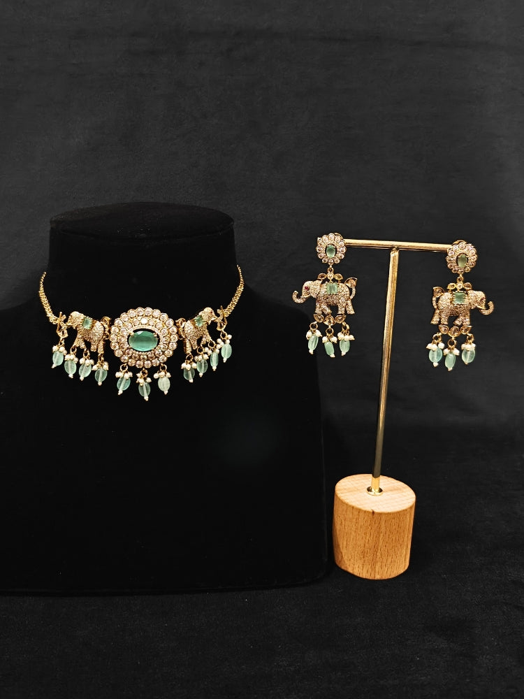 Close-up of an ornate traditional Mint Green (Mehendi gold Polish) Choker Diamond jewellery set and earrings with American Diamond, Pearls and Colored Stone. Elegant festive look with a high-quality imitation American diamond necklace set. A luxury American diamond necklace set styled beautifully for a wedding guest look in India.