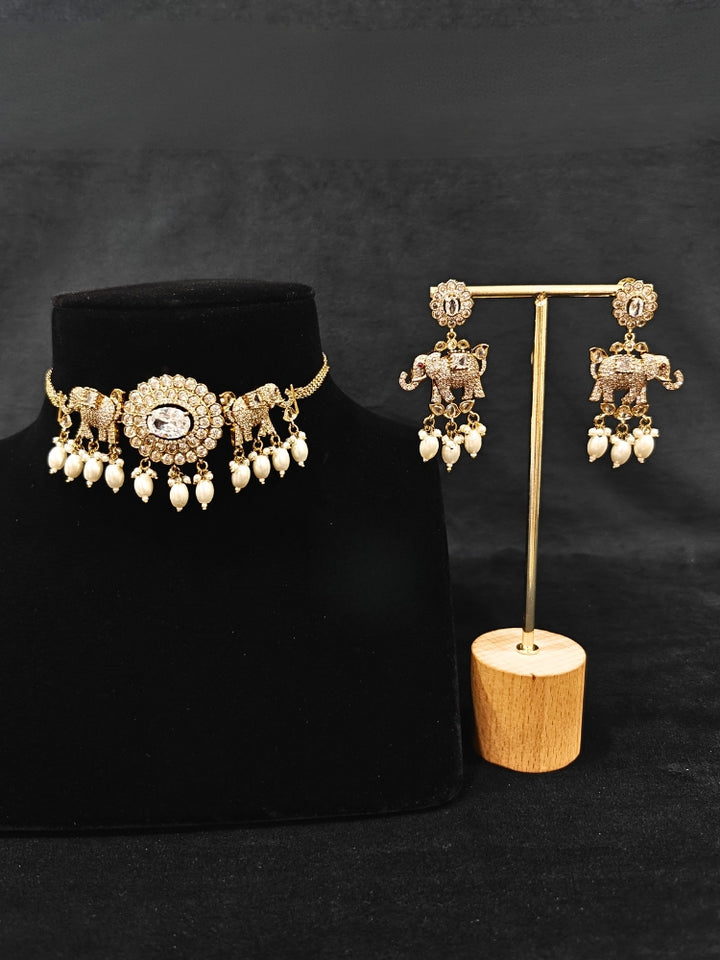 Close-up of an ornate traditional White (Mehendi gold Polish) Choker Diamond jewellery set and earrings with American Diamond and Pearls. Elegant festive look with a high-quality imitation American diamond necklace set. A luxury American diamond necklace set styled beautifully for a wedding guest look in India.