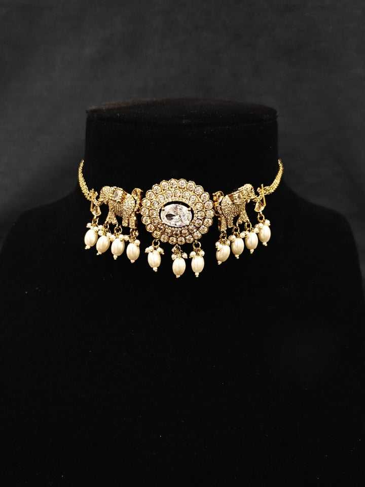 Close-up of an ornate traditional White (Mehendi gold Polish) Choker Diamond jewellery set and earrings with American Diamond and Pearls. Elegant festive look with a high-quality imitation American diamond necklace set. A luxury American diamond necklace set styled beautifully for a wedding guest look in India.
