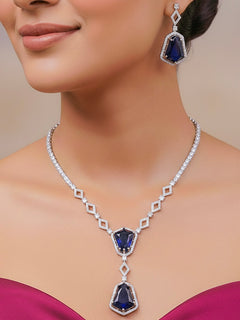 Close-up of a woman wearing an ornate Western Blue (Silver Polish) Diamond jewellery set and earrings with American Diamond and Colored Stones. Festive Diwali outfit styled with an American diamond artificial necklace. Close-up of a party look featuring a premium American diamond necklace.