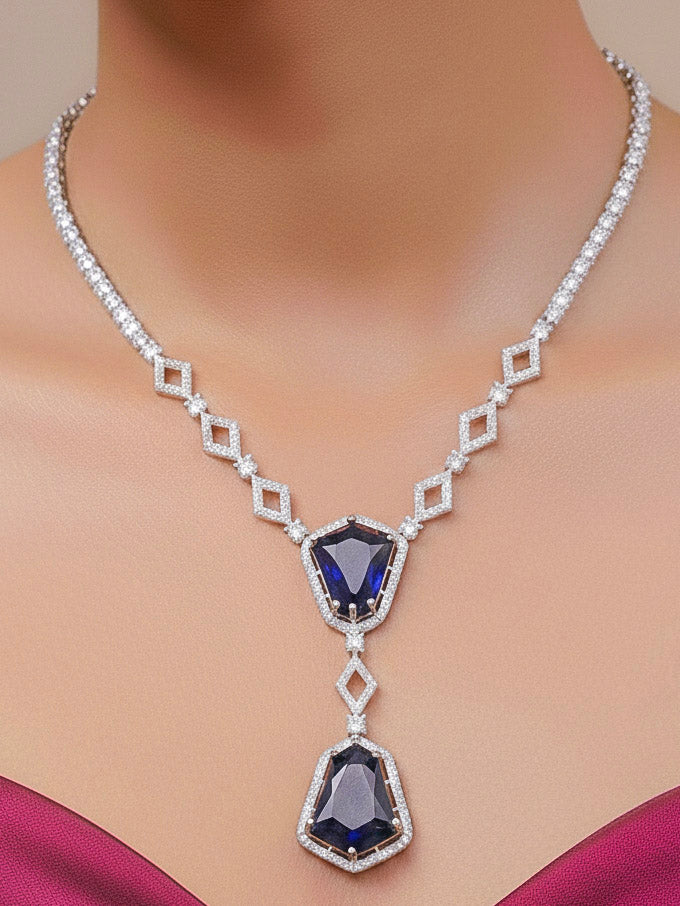Close-up of a woman wearing an ornate Western Blue (Silver Polish) Diamond jewellery set and earrings with American Diamond and Colored Stones. Festive Diwali outfit styled with an American diamond artificial necklace. Close-up of a party look featuring a premium American diamond necklace.