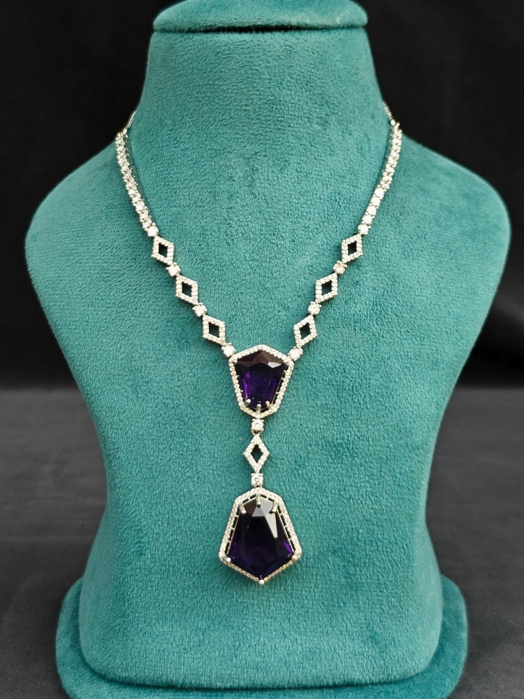 Close-up of an ornate Western Purple (Silver Polish) Diamond jewellery set and earrings with American Diamond and Colored Stones. Festive Diwali outfit styled with an American diamond artificial necklace. Close-up of a party look featuring a premium American diamond necklace.