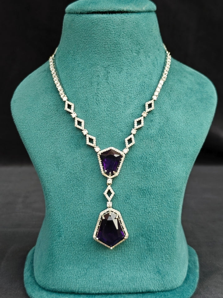Close-up of an ornate Western Purple (Silver Polish) Diamond jewellery set and earrings with American Diamond and Colored Stones. Festive Diwali outfit styled with an American diamond artificial necklace. Close-up of a party look featuring a premium American diamond necklace.
