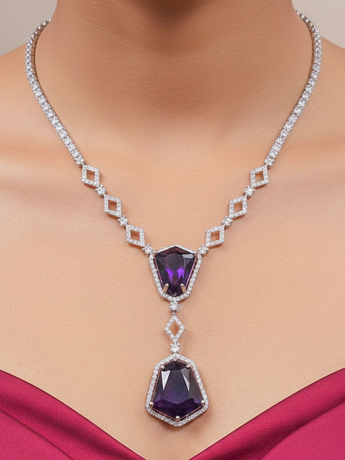 Close-up of a woman wearing an ornate Western Purple (Silver Polish) Diamond jewellery set and earrings with American Diamond and Colored Stones. Festive Diwali outfit styled with an American diamond artificial necklace. Close-up of a party look featuring a premium American diamond necklace.