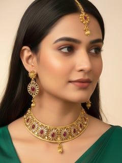 Close-up of a woman wearing an ornate traditional Red Diamond gold Polish Choker jewellery set and earrings and maangtikka with Baguette American Diamonds and Red Colored Stones. A woman wearing a luxury American diamond necklace set styled beautifully for a wedding guest look in India. Close-up of a featuring an anti-tarnish American diamond artificial necklace.