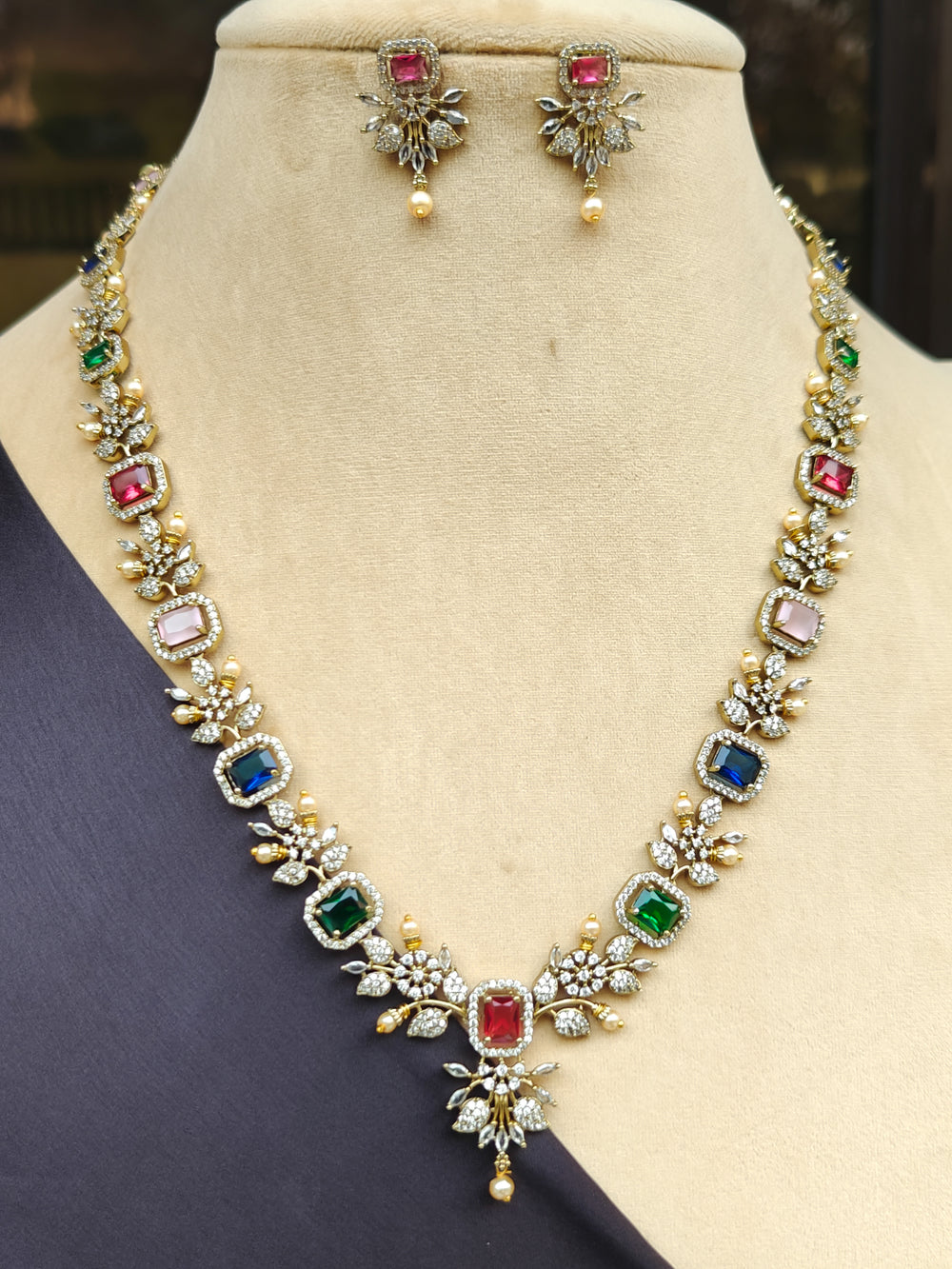 "Elegant woman wearing a luxurious artificial diamond and colored stone long  necklace with matching earrings, perfect for high-profile wedding receptions and formal galas. This high-end artificial diamond jewelry set combines style, elegance, and affordability for special occasions."
