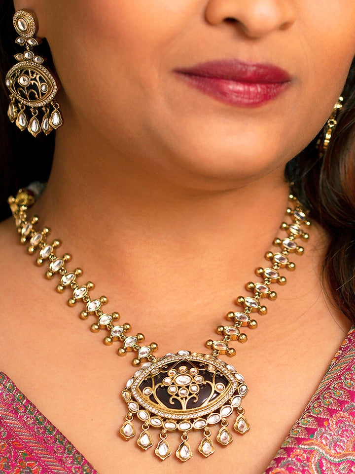 Close-up of a woman wearing an ornate traditional (Mehendi Polish Antique Finish) Dark Purple Collar jewellery set and earrings with Kundan, Monalisa Stone, Colored Stones and American Diamond. Woman wearing trending Kundan artificial jewelry for wedding season in India. Festive Diwali outfit paired with a premium Kundan jewelry piece.