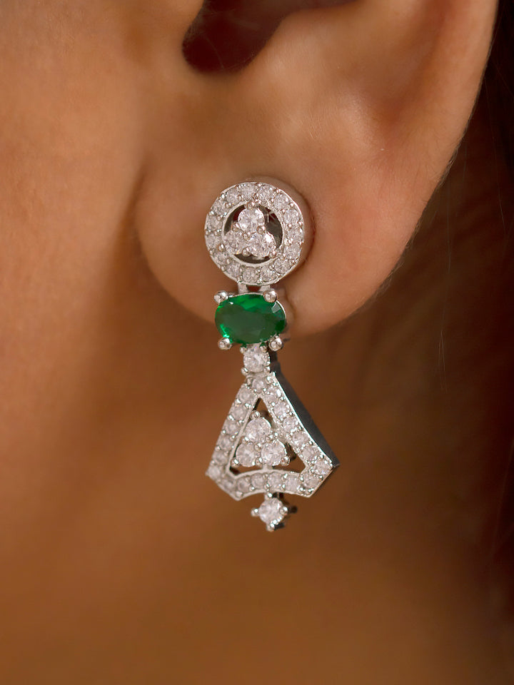 A woman in a traditional saree, wearing a gorgeous artificial diamond necklace with green colored stone paired with diamond earrings. This artificial diamond jewelry set offers a traditional yet modern touch for Indian brides, designed to add elegance and sophistication to any occasion.