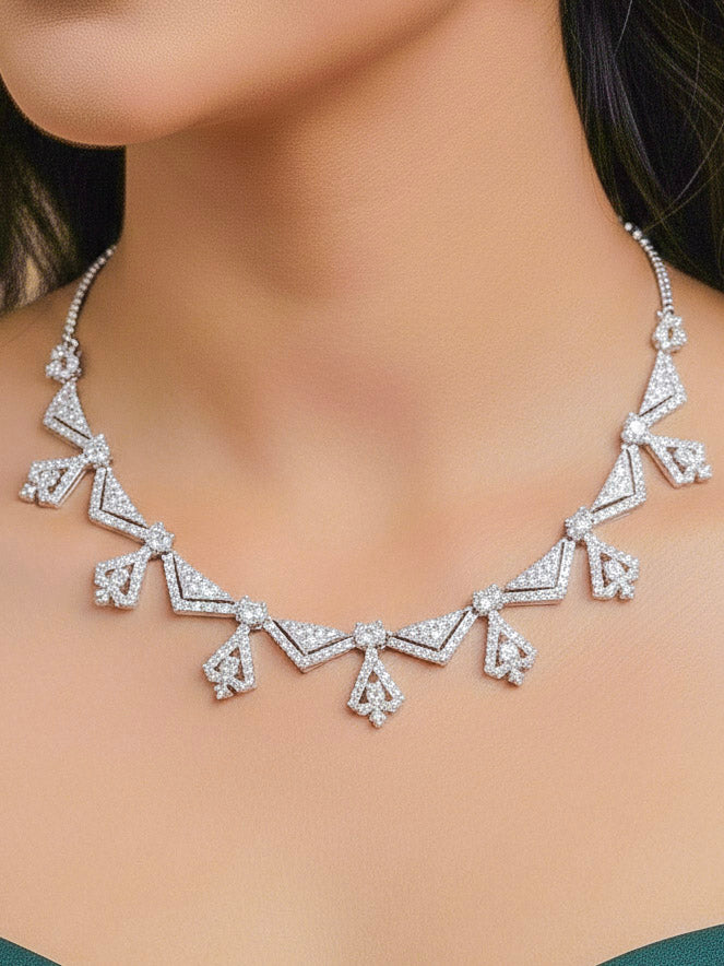 Close-up of a woman wearing an ornate Western White (Silver Polish) Collar Diamond jewellery set and earrings with American Diamond. Reception-ready look featuring a statement American diamond jewelry set. Party wear outfit completed with a lightweight American diamond necklace.