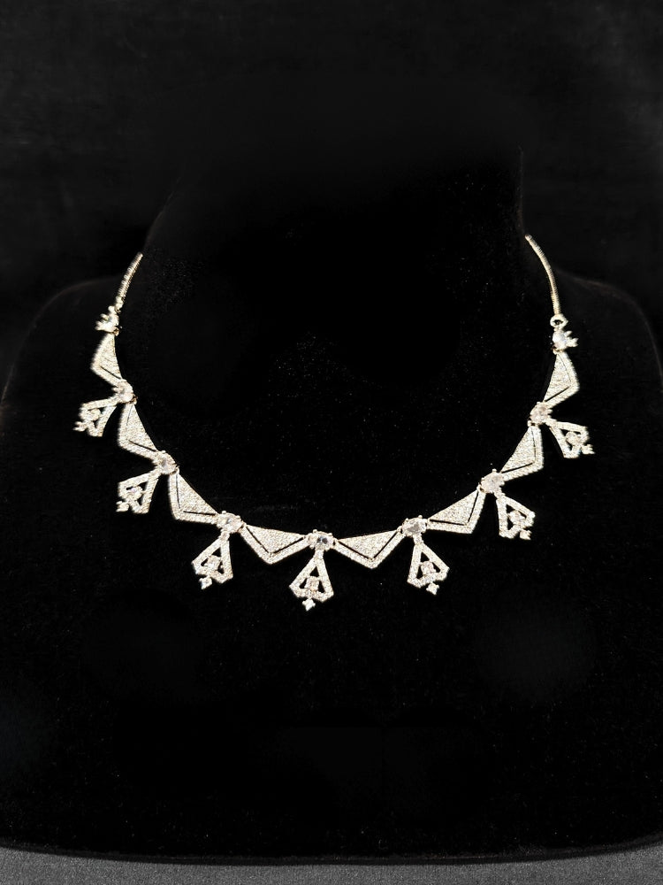 Close-up of an ornate Western White (Silver Polish) Collar Diamond jewellery set and earrings with American Diamond. Reception-ready look featuring a statement American diamond jewelry set. Party wear outfit completed with a lightweight American diamond necklace.