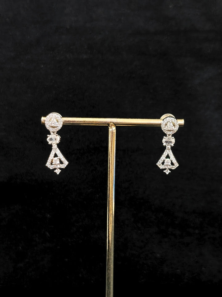 Close-up of an ornate Western White (Silver Polish) Collar Diamond jewellery set and earrings with American Diamond. Reception-ready look featuring a statement American diamond jewelry set. Party wear outfit completed with a lightweight American diamond necklace.