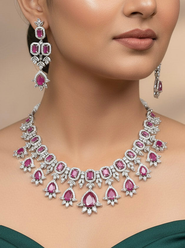 A beautiful woman wearing an elegant artificial diamond and pink colored stone necklace and matching earrings. This premium artificial diamond jewelry set is perfect for special occasions, from Indian weddings to engagement parties, offering sophisticated glamour without the high price tag."