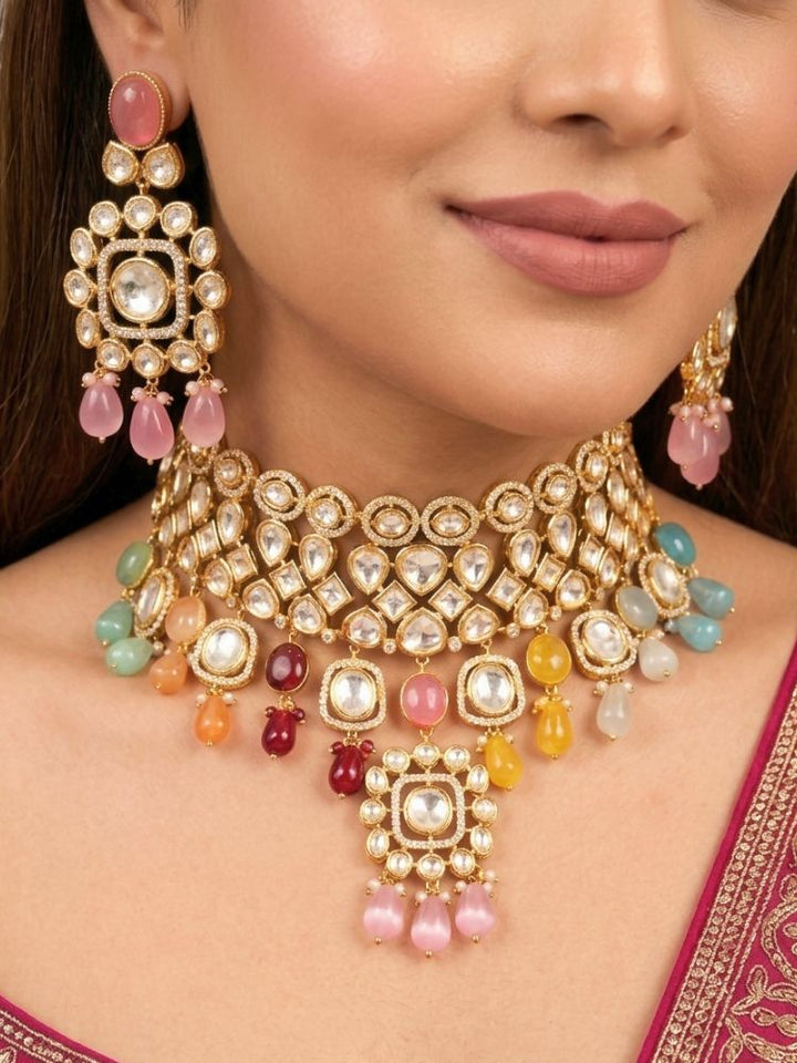 Close-up of a woman wearing an ornate traditional (Gold Polish) Choker jewellery set and earrings with Polki, American Diamond, Colored Stones and Tumble Beads. Wedding guest wearing a statement Polki artificial necklace for a reception party. Woman wearing trending Polki artificial jewelry for the wedding season in India.