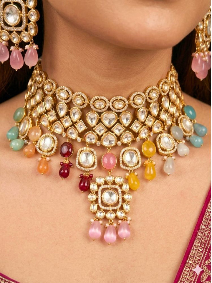 Close-up of a woman wearing an ornate traditional (Gold Polish) Choker jewellery set and earrings with Polki, American Diamond, Colored Stones and Tumble Beads. Wedding guest wearing a statement Polki artificial necklace for a reception party. Woman wearing trending Polki artificial jewelry for the wedding season in India.