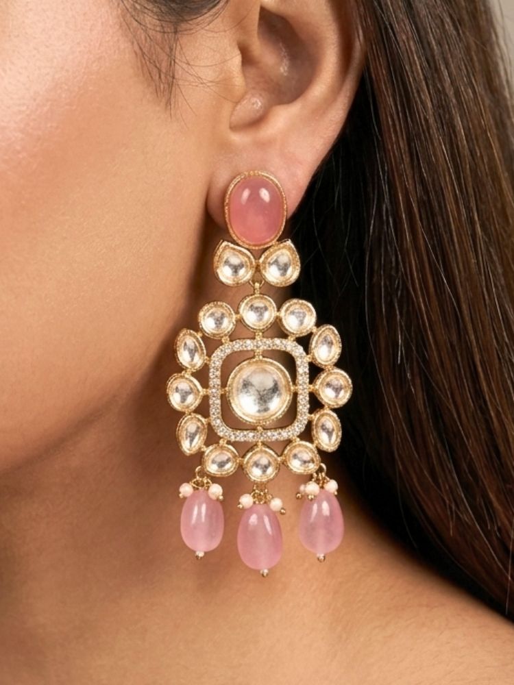 Close-up of a woman wearing an ornate traditional (Gold Polish) Choker jewellery set and earrings with Polki, American Diamond, Colored Stones and Tumble Beads. Wedding guest wearing a statement Polki artificial necklace for a reception party. Woman wearing trending Polki artificial jewelry for the wedding season in India.