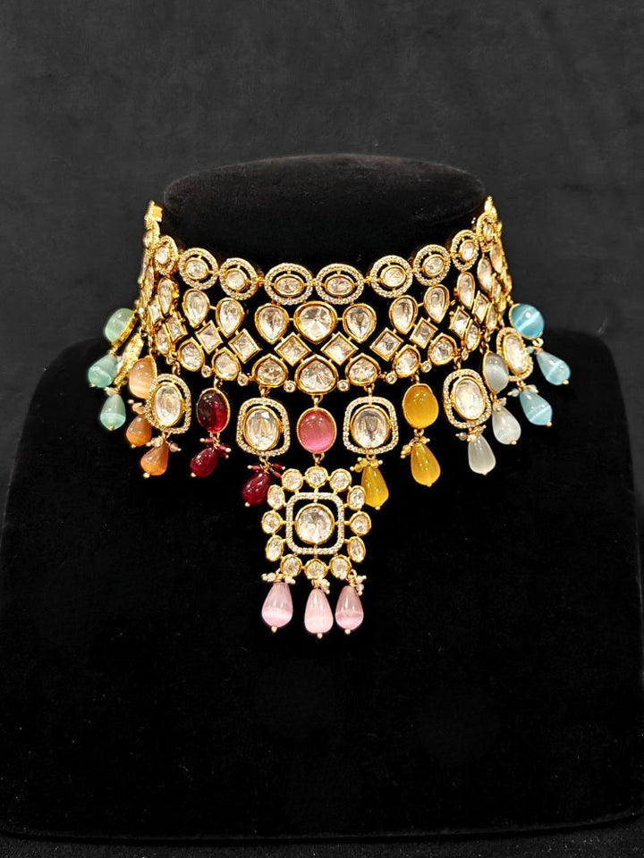 Close-up of an ornate traditional (Gold Polish) Choker jewellery set and earrings with Polki, American Diamond, Colored Stones and Tumble Beads. Wedding guest wearing a statement Polki artificial necklace for a reception party. Woman wearing trending Polki artificial jewelry for the wedding season in India.